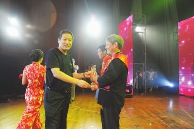 县委常委,公安局长潘益民向"孝老爱亲模范"张相民,谢小芹颁奖